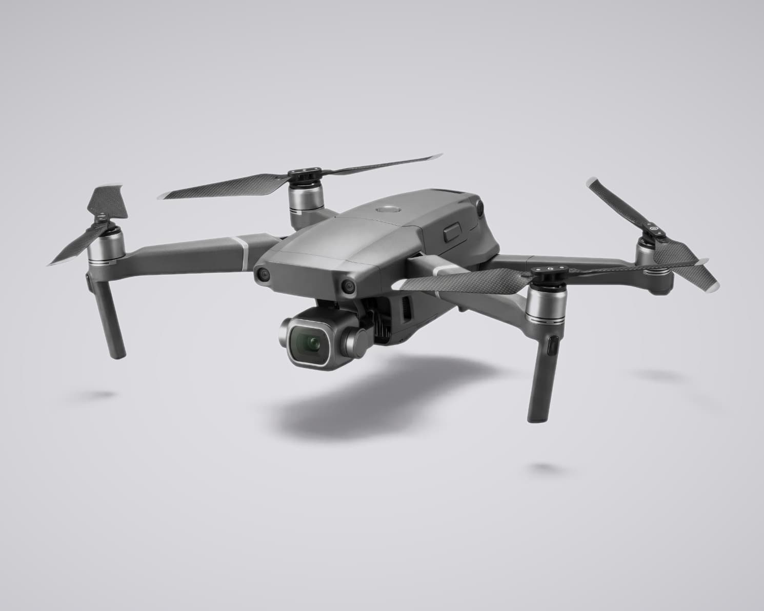 Caddi Drone — a compact folding quadcopter hovering, gimbal camera down.