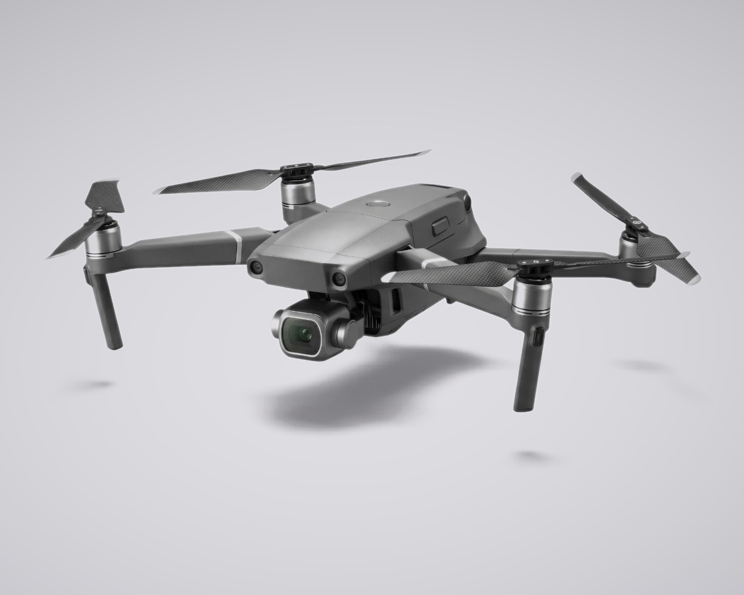 The Caddi Drone — a compact folding quadcopter with a brass-rimmed gimbal camera, fully in view against a soft studio backdrop.